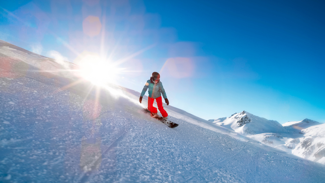 Woman snowboarding on mountain